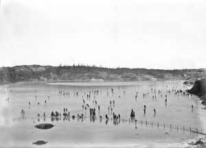 Distant winter scene of skaters on the ice of Lily Lake.