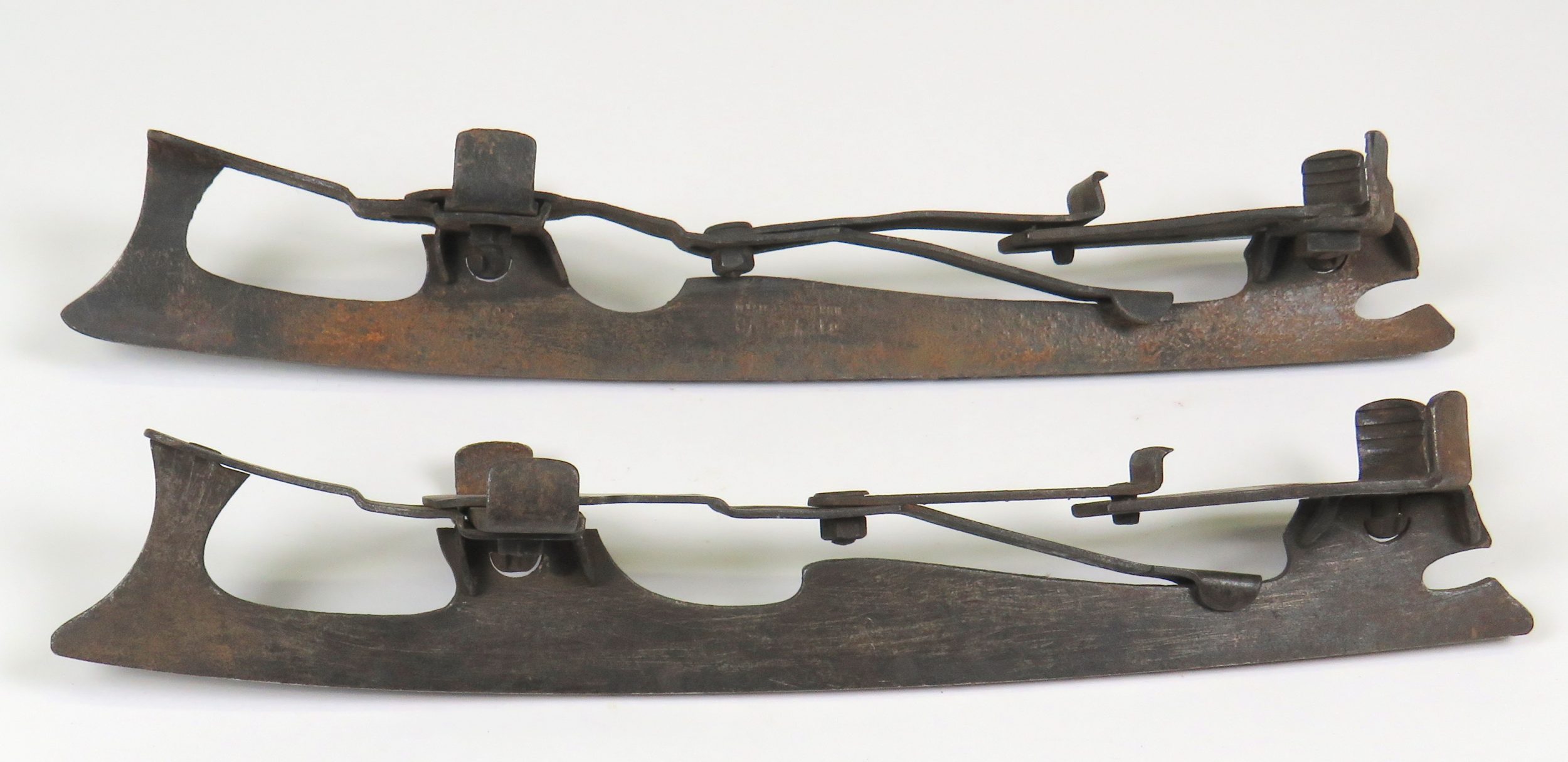A pair of all-metal skate blades in profile view. Locking mechanism shown.