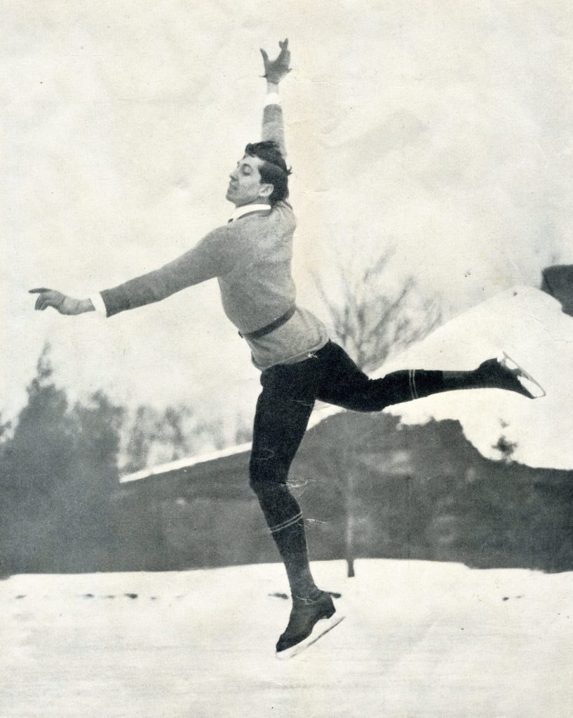 A black and white photo of a Lussi in mid-air from a jump on an outdoor rink. 
