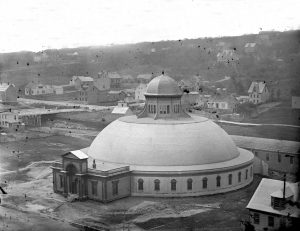 A black and white photo taken from a high angle of a large domed building.