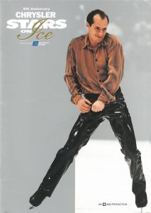 Light grey cover with white text. Kurt is posing with a smile on his face with his arms lowered to his outward stretched right leg. He is wearing a loose brown satin shirt tucked into black shiny pants.